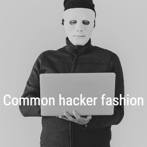 A man in a zip-up flannel jacket holding a laptop awkwardly, wearing a mask and hat. Text over the photo reads, 'HACKERMAN'